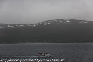 snow capped mountains and small boat 